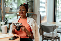 Smiling young afro-american woman with photo camera